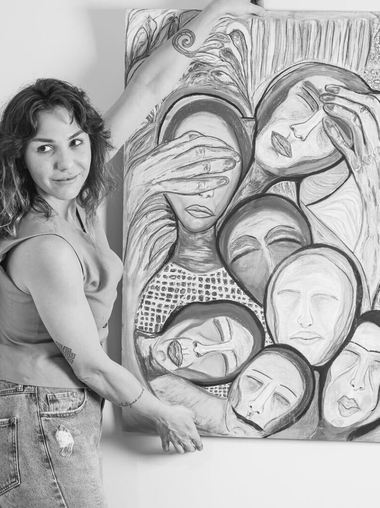 Imagem da Giuliana Fransceschi exibindo uma obra com vários rostos